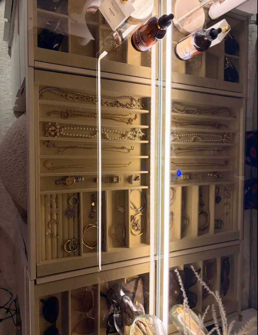 Table de maquillage rangée avec bijoux et parfums sur le plateau en verre